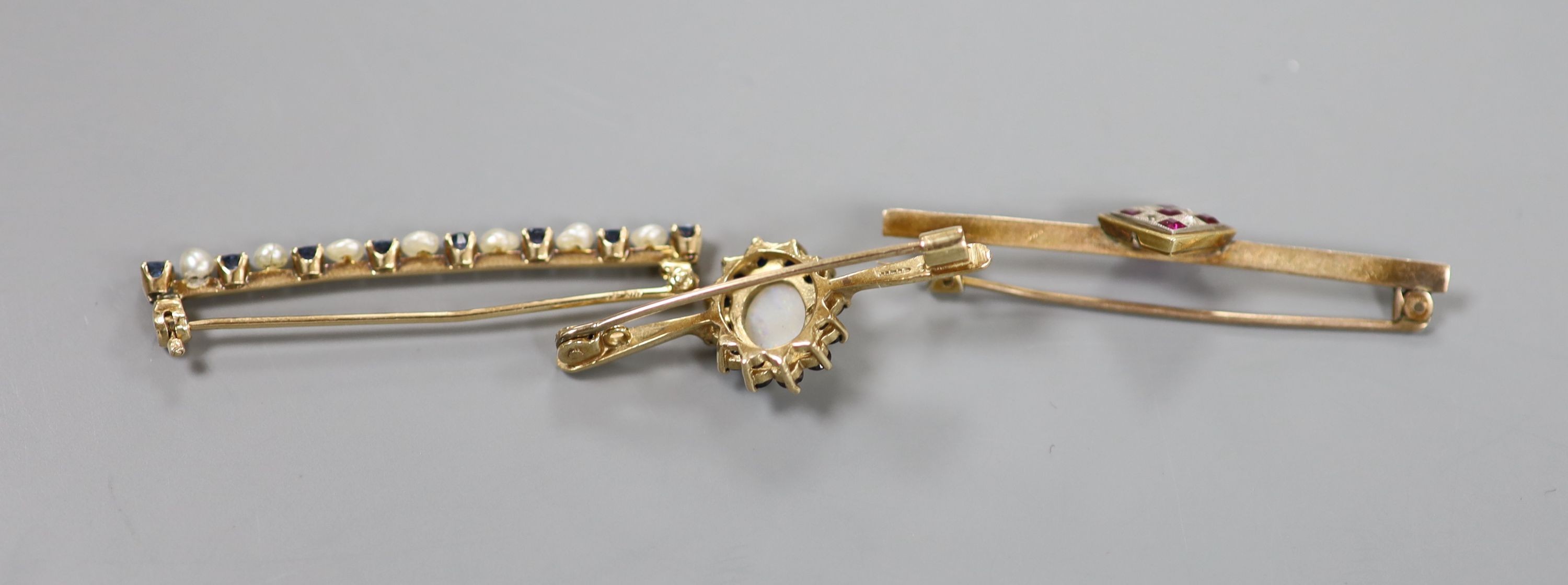 Two yellow metal and gem set bar brooches including ruby and diamond cluster, 46mm, gross 4.3 grams, a modern 9ct gold, white opal and sapphire cluster bar brooch, gross 3.1 grams and a cultured pearl set bar brooch.